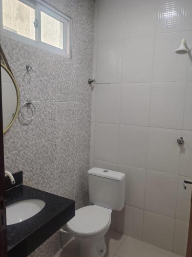 a bathroom with a toilet and a sink at Pousada Horbis in Guarabira