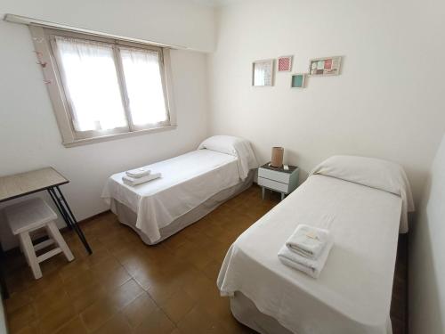a room with two beds and a table and a window at Casa Nanet Hotel in Mar del Plata