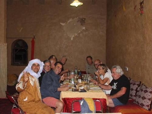 a group of people sitting around a table eating at Hamada Kem-Kem Tafraoute in Tafraoute Sidi Ali