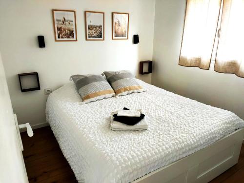 a bedroom with a white bed with two pillows at L'instant voyageur in Virsac