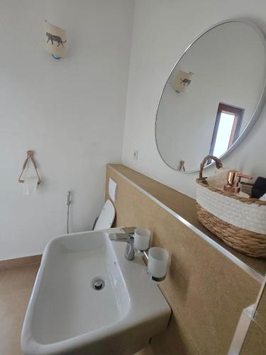 a bathroom with a white sink and a mirror at Paida Moyo Ocean Breeze Apartment in Zanzibar City