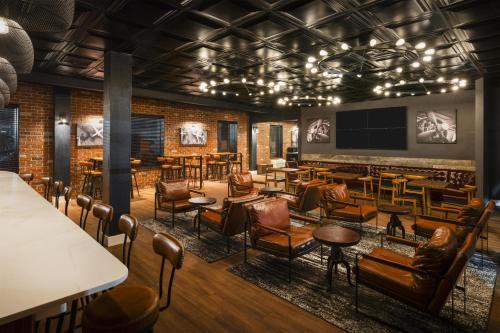 a room with tables and chairs and a bar at Aiden by Best Western Newark Airport in Newark