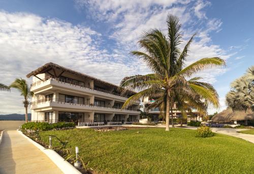 a building with a palm tree in front of it at El Secreto Residencial in Zihuatanejo