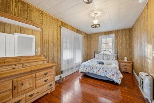 a bedroom with a bed and wooden floors and walls at 1875 Historic Manor, 5 Acres Near Helen & Wineries in Baldwin