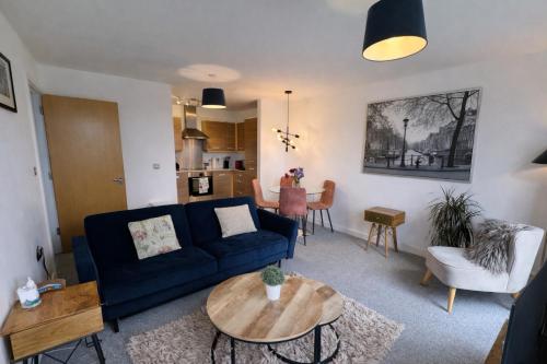 a living room with a blue couch and a table at Home2Home - Train Station in Cambridge