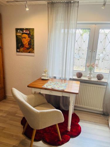 a table and a chair in a room with a window at Ferienwohnung am Weinberg in Flonheim