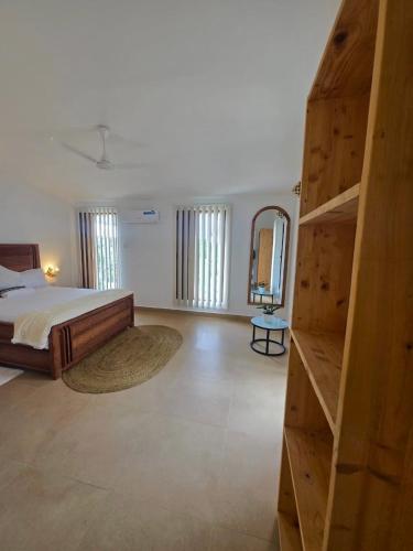 a bedroom with a large bed and a wooden ladder at Paida Moyo Ocean Breeze Apartment in Zanzibar City