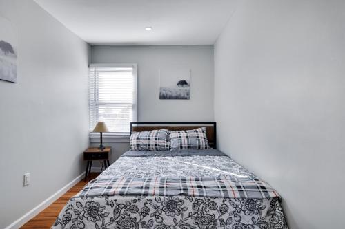 a bedroom with a bed in a white room at 2BR Apt Near EWR & NYC • Workspace + Parking in Newark