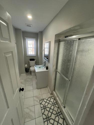 a bathroom with a shower and a toilet at 2BR Apt Near EWR & NYC • Workspace + Parking in Newark