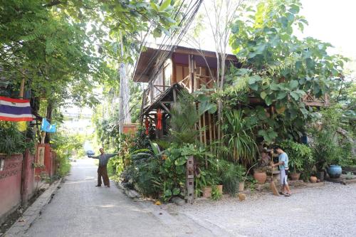 a man standing in front of a building with plants at BaanBooLoo Village in Chiang Mai