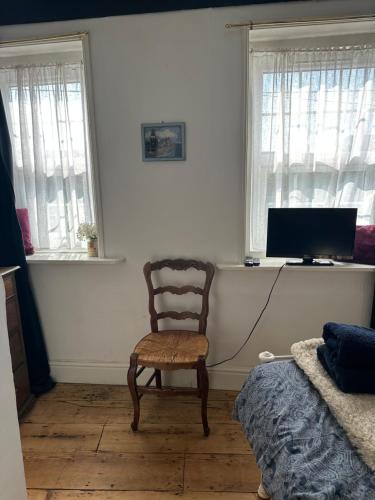 a living room with a chair and a television at The Pepper Pot in Lympstone