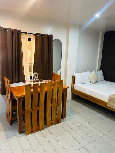 a room with a table and a bed and a table and chairs at Tiwi's Travellers Inn - Solar Powered, Starlink, Scooter Rental, Palawan Tours in Puerto Princesa City