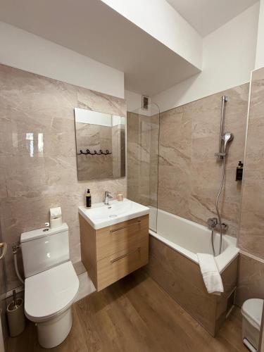 a bathroom with a toilet and a sink and a tub at Hotel Bonaparte in Bastia