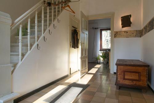 a hallway of a house with a white staircase at Zur Waldschmiede in Kakenstorf