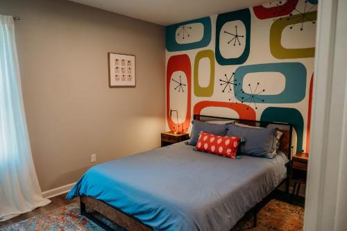 a bedroom with a bed and a wall with clocks at Freetown Blueplex Downtown Lafayette in Lafayette