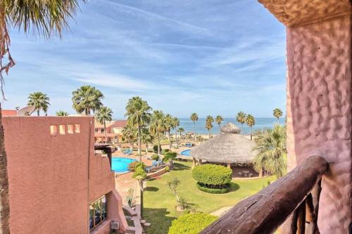 a view of a resort with a pool and palm trees at Unique Colorful Condo on 3rd Floor Pinacate 321 in Puerto Peñasco