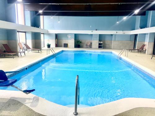a large swimming pool with blue water in a building at Comfort Inn Manchester Airport in Manchester