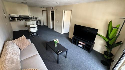 a living room with a couch and a flat screen tv at Steps from UCLA Westwood 1 Bd 1Ba in Los Angeles