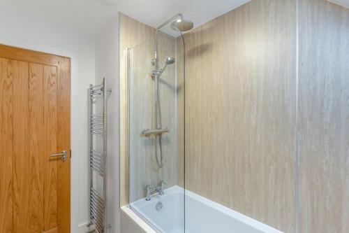 a bathroom with a shower with a tub and a sink at 3 Bed in Lairg oc-96459 in Achfary