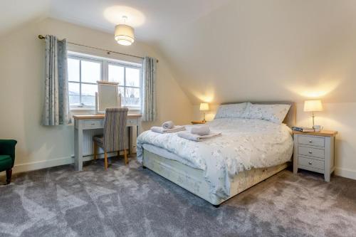 a bedroom with a bed and a desk and a window at 3 Bed in Lairg oc-96459 in Achfary