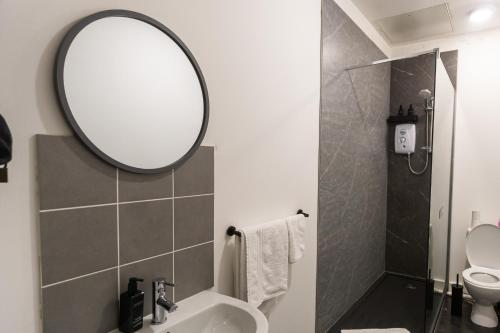 a bathroom with a sink and a mirror at Cozy flat by Birmingham Canals & City Centre in Birmingham