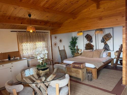 a bedroom with a bed and a table and chairs at São Jorge Spot - Alojamento in Velas