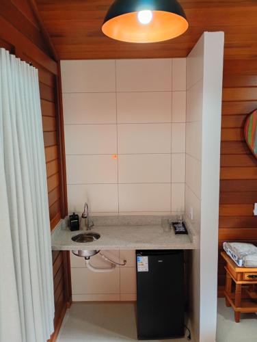 a small kitchen with a sink in a room at Chalés da Preguiça in Pedra Menina