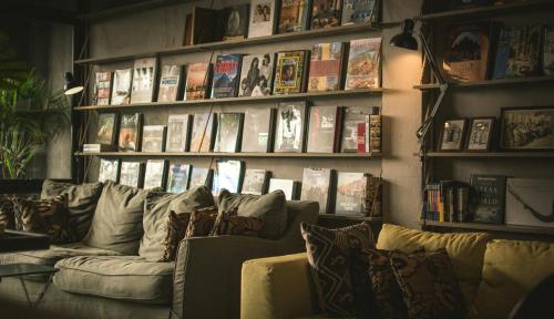a living room with a couch and books at Heyyyy Bangkok in Bangkok