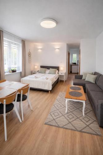 a living room with a bed and a couch and a table at Dom Gościnny Ania in Wisełka