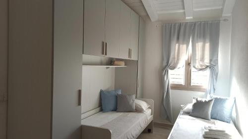 a white room with a bed and a window at Villa 21 in Budoni