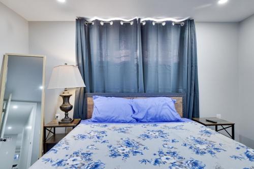 a bedroom with a bed with blue sheets and blue curtains at 4BR Newark Stay w/ Parking And Fast Wi-Fi in Newark