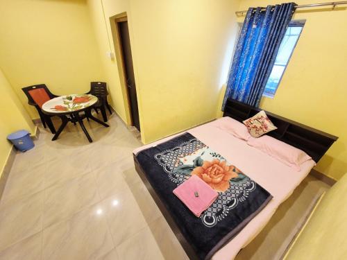 a small room with a bed and a table at Nmck Homestay in Guwahati