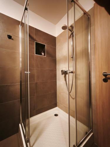 a shower with a glass door in a bathroom at FoBala Apartman in Balatonföldvár