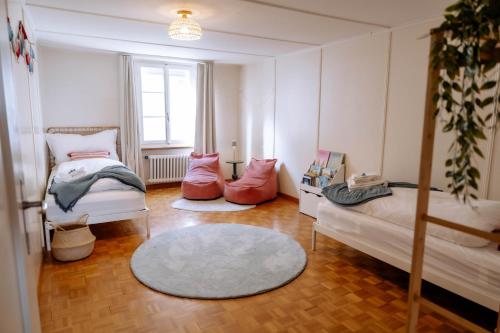a room with two beds and a couch and a rug at Cara Nima Schwyz in Schwyz