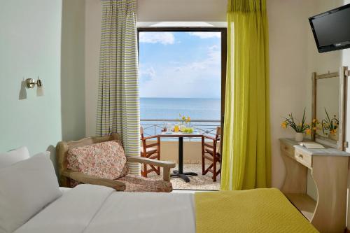 a bedroom with a room with a view of the ocean at Pharos Rooms in Ilia