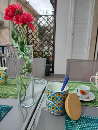 a vase with a red flower sitting on a table at La Casa dello Zio Pollo in Dogliani