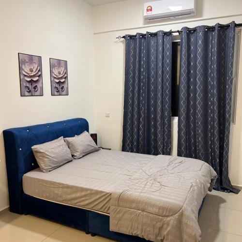 a bed with a blue headboard in a bedroom at Cloud9 Homestay D Aman Residence in Alor Setar