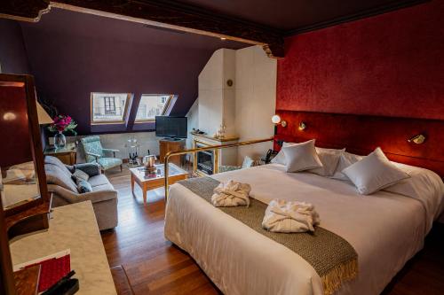 a bedroom with a large bed and a living room at Casa Inquieta Hotel Boutique in Seville