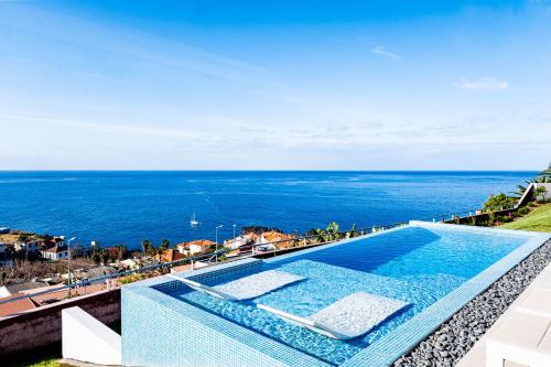 a swimming pool with a view of the ocean at Villa Infinityviews Madeira in Câmara de Lobos