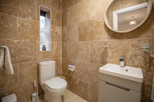 a bathroom with a toilet and a sink and a mirror at Yarm Bank House Apartments in Yarm