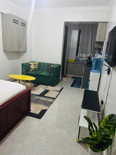 a living room with a green couch and a table at Bella apartment studios town in Meru