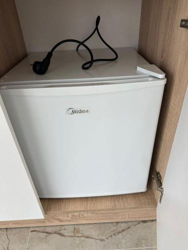 a white refrigerator with a black charger on top of it at Qyteza guest house in Shkodër