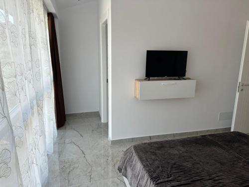 a room with a tv on a white wall at Qyteza guest house in Shkodër