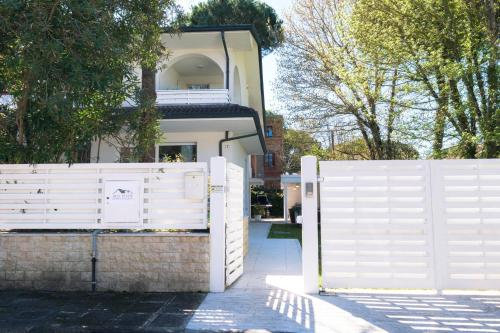 a white fence in front of a house at Villa Irene in Cervia