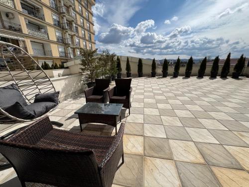 a patio with chairs and a table and a building at Sonny Penthouse 2 in Gnjilane