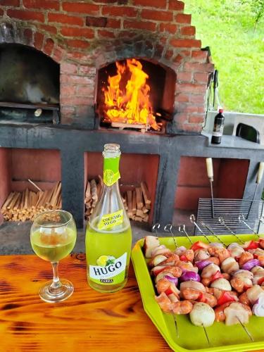 a bottle of wine next to a plate of food and a glass at Casa MATEO in Topliţa