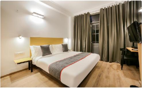 a hotel room with a large bed and a desk at Hotel Shree Jee in Gurgaon