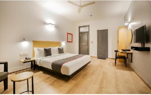 a hotel room with a large bed and a couch at Hotel Shree Jee in Gurgaon