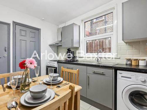 a kitchen with a table and a sink and a dishwasher at East LDN Guest Rooms and Amenities in London