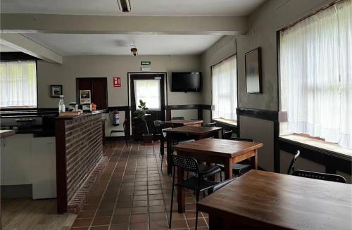 a restaurant with tables and chairs in a room at Albergue Gerekiz AMAGI, exclusivo peregrinos in Flores
